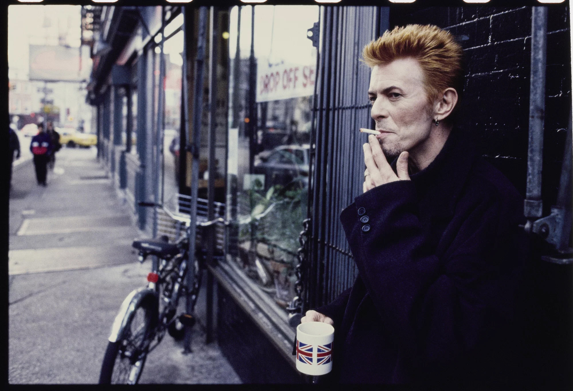 Kevin Cummins, David Bowie in front of Tea & Sympathy in New York City, 10 January 1997