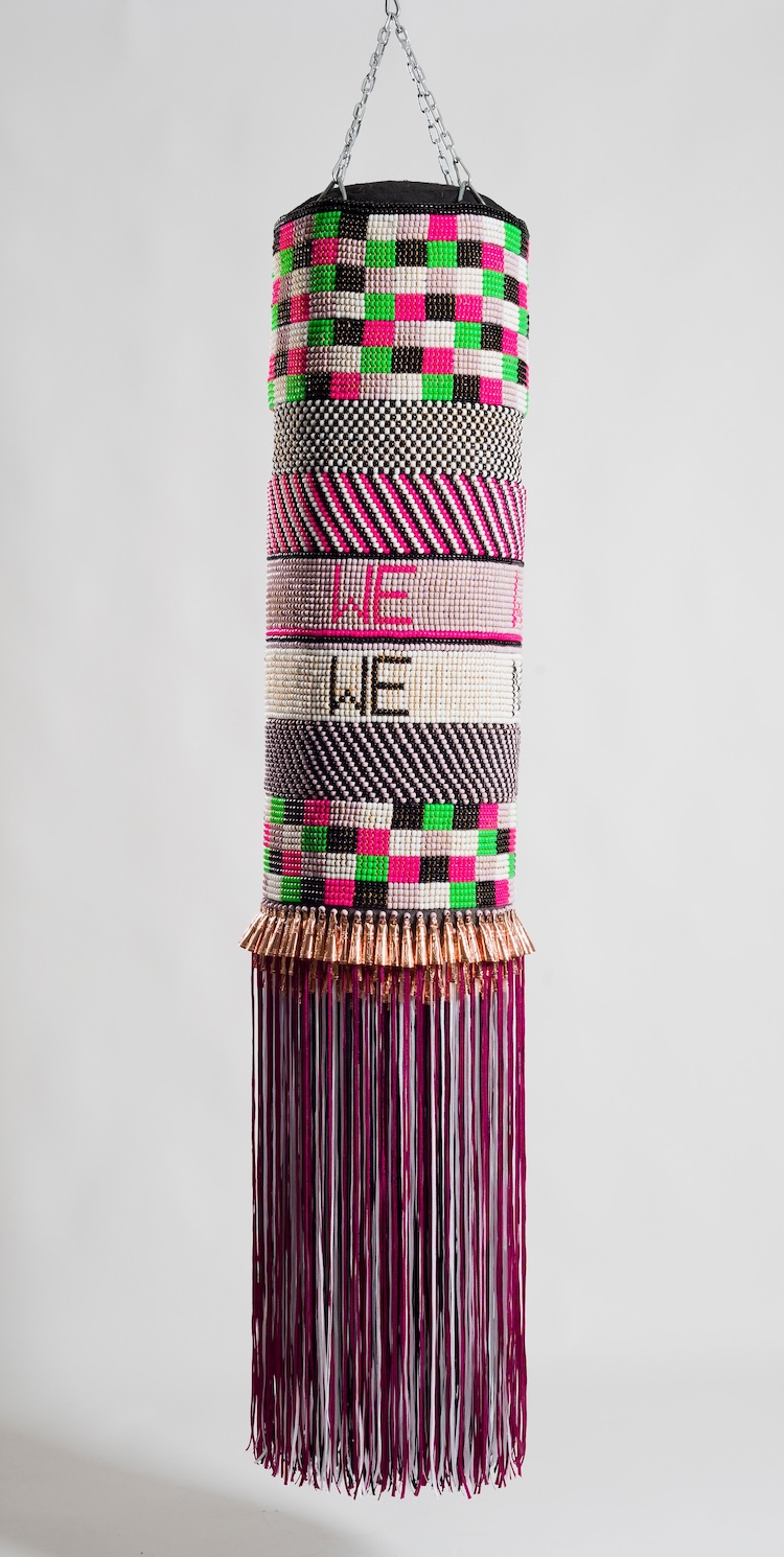 Jeffrey Gibson, Mississippi Band of Choctaw Indians and of Cherokee descentWhat We Want, What We Need, 2014 Found punching bag, glass beads, artificial sinew, copper jingles, nylon fringe, and steel chain 71 in x 14 in x 14 in. Crystal Bridges Museum of American Art, Bentonville, Arkansas, 2015.13.